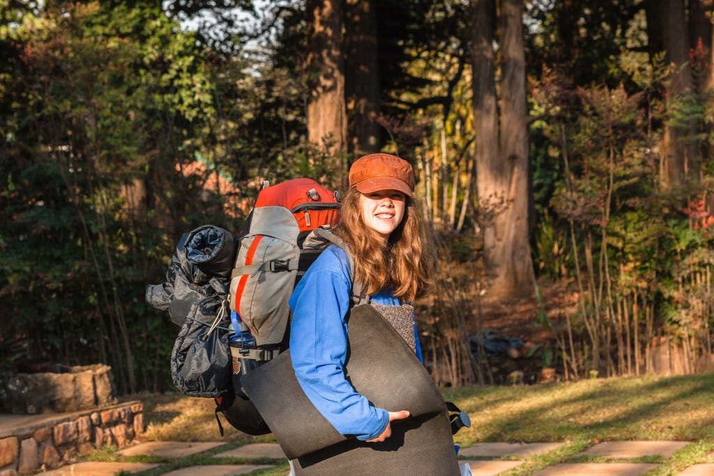 Teenage girl on departure to outdoors with hiking camping backpack