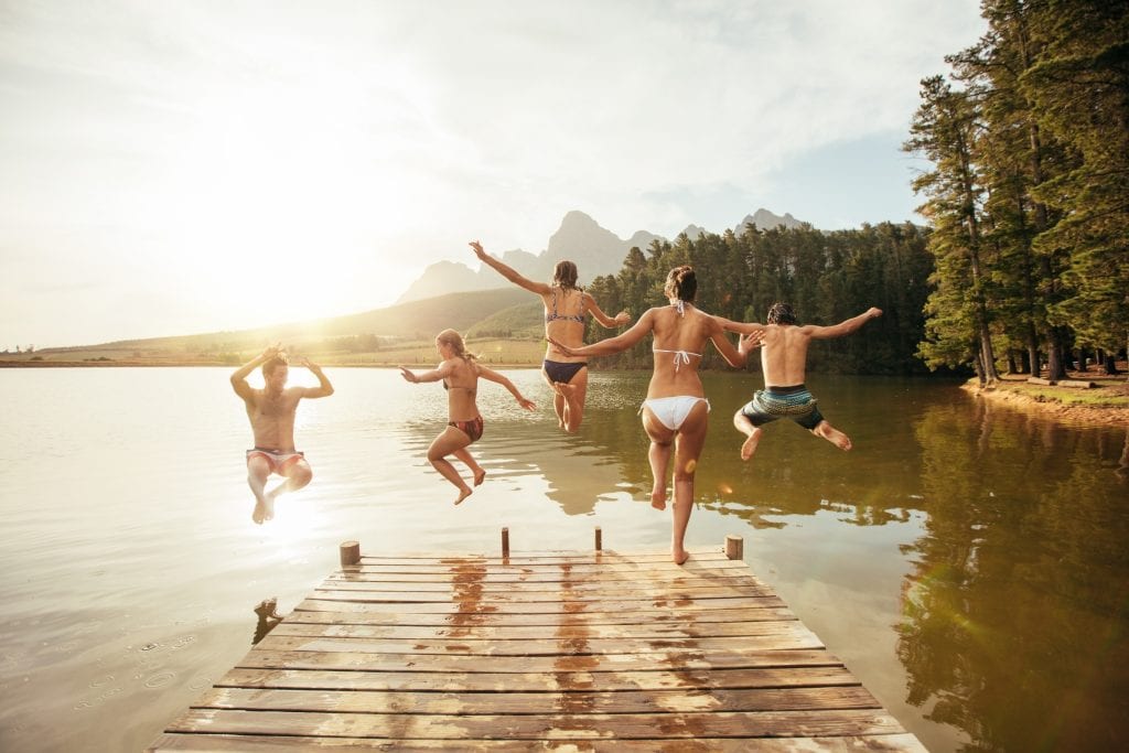 bigstock Friends Jumping Into The Water 119847851