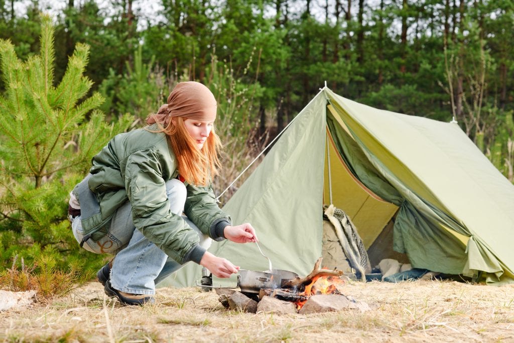 bigstock Camping Woman Tent Cook Food F 17073179 2