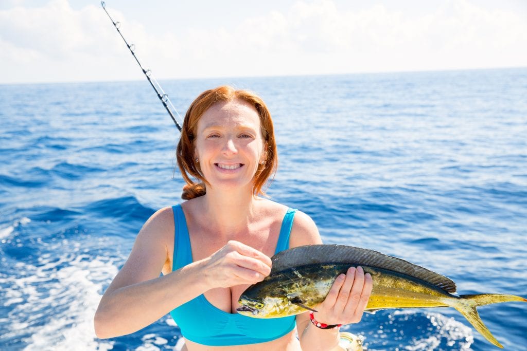 bigstock Woman fishing Dorado Mahi mahi 64158169