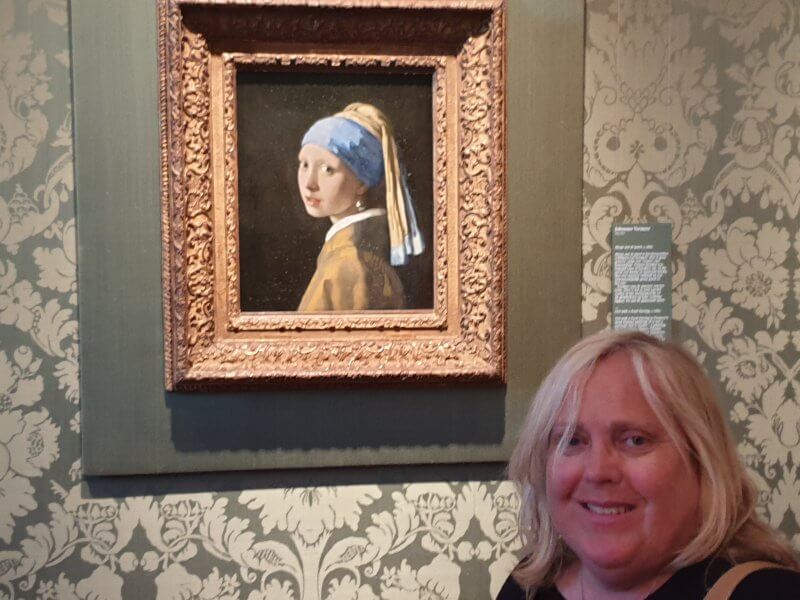 In front of the original painting of the Girl with the Pearl Earring at the Mauritshuis museum